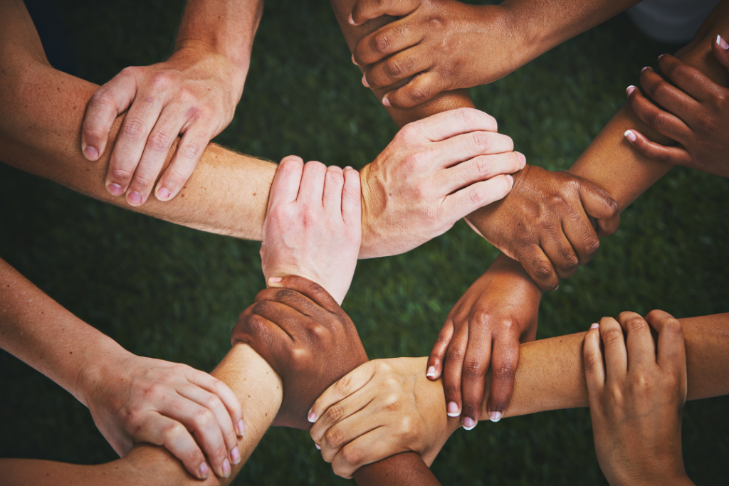 Interlocked hands of different skin tones